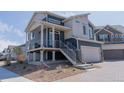 Modern two-story home with a metal staircase, landscaped with natural stone and gravel, and a two-car garage at 16382 E 111Th Dr, Commerce City, CO 80022