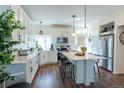 Modern kitchen featuring white cabinets, stainless steel appliances, a center island, and beautiful hardwood floors at 16382 E 111Th Dr, Commerce City, CO 80022