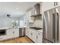Bright modern kitchen with stainless steel appliances, white cabinets, and an island sink with black fixtures at 42982 Colonial Trl, Elizabeth, CO 80107