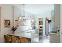 Bright kitchen showcasing a breakfast bar, open shelving, and modern lighting at 3410 W 31St Ave, Denver, CO 80211