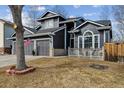 Attractive two-story home with a two-car garage and manicured lawn beneath a mature tree at 10535 Cottoneaster Way, Parker, CO 80134