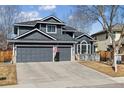 Charming two-story home boasts a two-car garage, well-maintained lawn, and classic American flag display at 10535 Cottoneaster Way, Parker, CO 80134