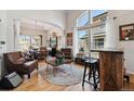 Bright living room with high ceilings, large windows, stylish furnishings, and wood floors at 10535 Cottoneaster Way, Parker, CO 80134