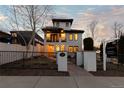 Elegant two-story home with a tiled roof, balconies, a landscaped yard, and a wrought iron fence at 579 Madison St, Denver, CO 80206