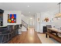 Open living area with hardwood floors, fireplace, bar with seating, and staircase access at 579 Madison St, Denver, CO 80206