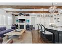 Inviting living space featuring a fireplace, exposed beams, and an open layout to the kitchen area at 579 Madison St, Denver, CO 80206