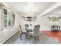 Cozy dining room features a glass table, hardwood floors, and large windows providing plenty of natural light at 591 Nome St, Aurora, CO 80010