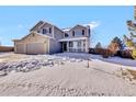 Two-story house with gray siding, three-car garage, and snowy front yard at 1607 Rosedale St, Castle Rock, CO 80104