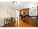 Kitchen with stainless steel appliances, stylish countertops, wood floors and breakfast nook at 9654 W Elmhurst Pl, Littleton, CO 80128