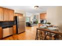 Open kitchen flows into a living room area with a lovely fireplace and stainless appliances at 9654 W Elmhurst Pl, Littleton, CO 80128