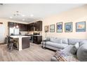 Open-concept living room and kitchen with modern decor and hardwood flooring at 15546 W 64Th Loop # C, Arvada, CO 80007