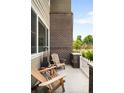 Relaxing patio with wood chairs, a small table, and a view of the green backyard at 15546 W 64Th Loop # C, Arvada, CO 80007