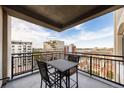 Balcony with wrought iron railing, table and chairs and a beautiful city view at 1827 N Grant St # 1000, Denver, CO 80203
