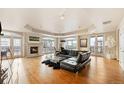 Bright living room with hardwood floors, fireplace, a large black couch and french doors to a balcony at 1827 N Grant St # 1000, Denver, CO 80203