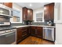 Modern kitchen with stainless steel appliances, granite countertops, and dark wood cabinetry at 3649 N Garfield St, Denver, CO 80205