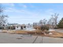 A view of the exterior of a well-kept residence, complemented by mature trees at 1195 Ammons St, Lakewood, CO 80214