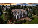 Beautiful home featuring outdoor living space and landscaped yard nestled among mature trees in a serene setting at 730 Summerwood Dr, Golden, CO 80401