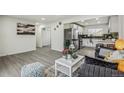 Open-concept living room flows seamlessly into a modern kitchen with stainless steel appliances and stylish countertops at 3540 E 91St Ave, Thornton, CO 80229
