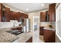 Modern kitchen featuring granite countertops, stainless steel appliances, and dark wood cabinets at 1532 Meade St, Denver, CO 80204