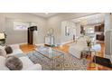 Bright living room featuring hardwood floors, a stylish rug, and an open layout flowing into the dining area at 1532 Meade St, Denver, CO 80204