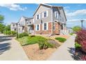 Well-maintained townhomes showcasing stone and siding exteriors, enhanced by mature landscaping and sidewalks, creating a desirable community at 12766 Jasmine St # D, Thornton, CO 80602
