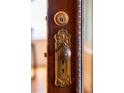 Ornate antique doorknob and lock with a detailed plate on a dark stained door at 506 N Marion St, Denver, CO 80218