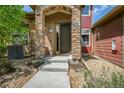 Charming front entrance featuring a stone arch and well-manicured landscaping at 8552 Gold Peak Ln # F, Highlands Ranch, CO 80130
