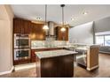 Modern kitchen with stainless steel appliances, granite countertops, and island at 8552 Gold Peak Ln # F, Highlands Ranch, CO 80130