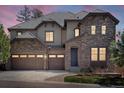 Beautiful home featuring a 3-car garage, stone accents, and a tile roof under a colorful, picturesque sunset sky at 6877 Northstar Ct, Castle Rock, CO 80108