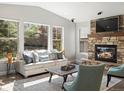 Inviting living room with a stone fireplace, large windows, and comfortable seating for relaxation at 6877 Northstar Ct, Castle Rock, CO 80108