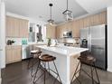 Bright kitchen with stainless steel appliances, a large island, modern cabinets, and stylish pendant lighting at 8711 E Hampden Ave # 20, Denver, CO 80231
