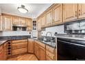 Well-lit kitchen showcasing wood cabinetry, granite countertops, stainless steel appliances, and a modern sink at 1551 Larimer St # 1803, Denver, CO 80202