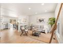 Bright open-concept living space with wood floors, modern decor, and seamless transition to the dining area at 2023 S Idalia St, Aurora, CO 80013