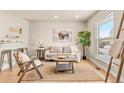 Cozy living room featuring neutral paint, wood floors, a jute rug, and comfortable seating arrangement at 2023 S Idalia St, Aurora, CO 80013