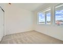 Bright, carpeted bedroom with large windows offering lots of natural light and closet at 647 Skyhook St, Erie, CO 80516