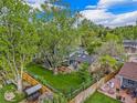 Aerial view of a landscaped backyard with a patio, lawn, fence, and a two-story home at 12175 W 68Th Pl, Arvada, CO 80004