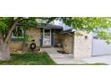 Close-up of the charming home's front entrance with brick facade and well maintained landscaping at 12175 W 68Th Pl, Arvada, CO 80004