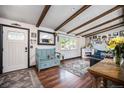 Inviting living room featuring hardwood floors, wooden ceiling beams, fireplace, and a bright window view at 12175 W 68Th Pl, Arvada, CO 80004