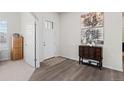 Bright and spacious entryway with wood-look floors and art at 12664 Ulster St, Thornton, CO 80602