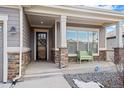 Inviting front porch with stone accents and a charming bench at 12664 Ulster St, Thornton, CO 80602
