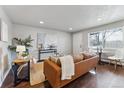 A cozy living room features dark wood floors, neutral walls, modern furniture, and a large window at 1275 Winona Ct # B, Denver, CO 80204