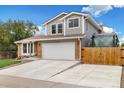 Two-story home with brick and siding, large driveway with garage, and partial wooden fence at 11131 Seton Pl, Westminster, CO 80031