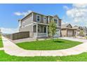 Two-story home boasts a well-manicured lawn and inviting front porch at 9886 Ceylon Ct, Commerce City, CO 80022