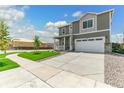 View of the two-story home, the well-kept lawn and a wide driveway at 9886 Ceylon Ct, Commerce City, CO 80022