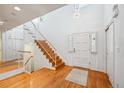 Bright entryway with hardwood floors, staircase, and modern lighting fixtures at 7190 S Poplar Ct, Centennial, CO 80112