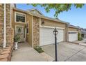 Home exterior showcasing a 2-car garage and stone detailing at 6727 W Yale Ave, Lakewood, CO 80227