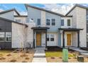A modern townhome exterior with a stone facade and a pop of color from the cheerful yellow front door at 5688 N Killarney Ct, Aurora, CO 80019