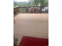 Large deck with wooden rails and a view of the surrounding trees and neighboring houses at 14751 E 24Th Ave, Aurora, CO 80011