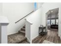 Bright entryway featuring hardwood floors, staircase with wooden handrail, and access to the main living area at 17470 E 95Th Pl, Commerce City, CO 80022