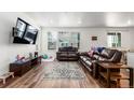 Spacious living room featuring hardwood floors, large windows, and comfortable seating area at 17470 E 95Th Pl, Commerce City, CO 80022